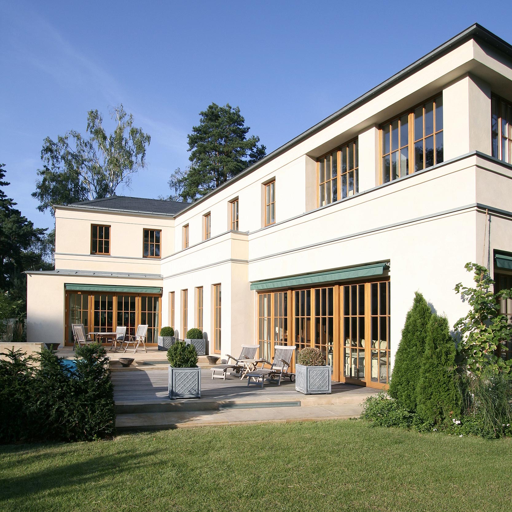 Sandstein, durchgefärbter Massivputz und lasierte Lärchefenster Sandstein, durchgefärbter Massivputz und lasierte Lärchefenster