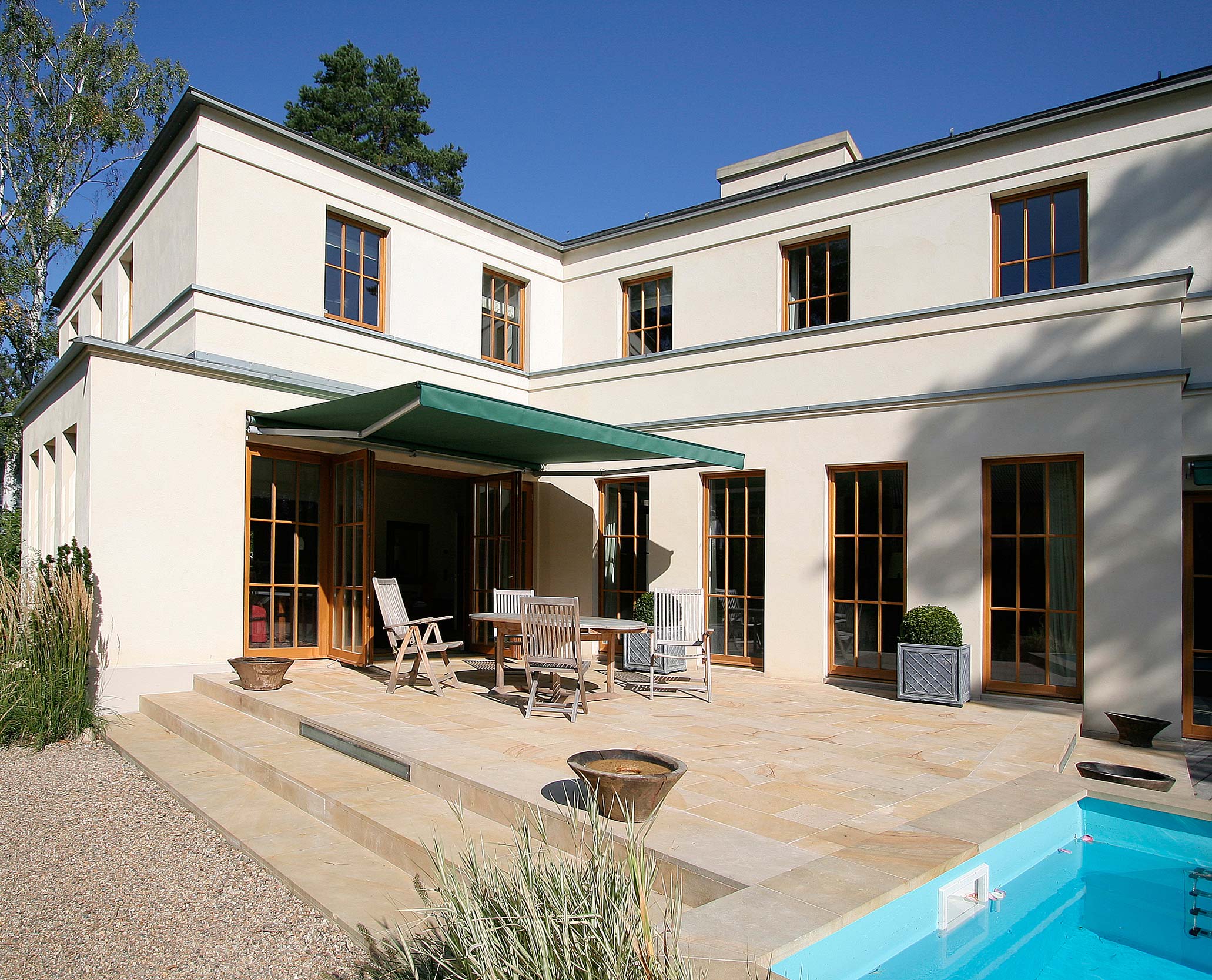 Auf der Sommerterrasse befindet sicht der Essplatz unter einer großen Markise. Auf der Sommerterrasse befindet sicht der Essplatz unter einer großen Markise.